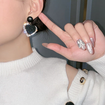 Ohrringe aus Gold mit einem dunklen Herzen